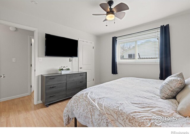 bedroom featuring light wood finished floors, a ceiling fan, and baseboards