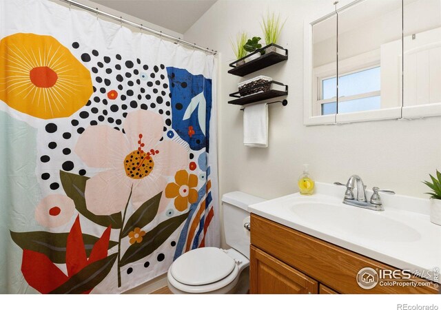 full bathroom featuring curtained shower, vanity, and toilet