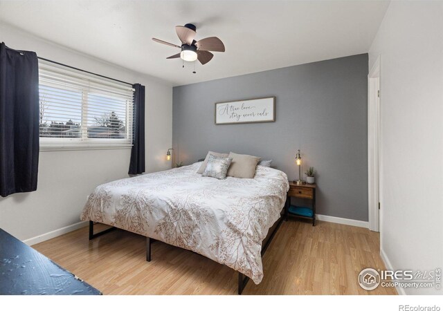 bedroom with a ceiling fan, baseboards, and wood finished floors