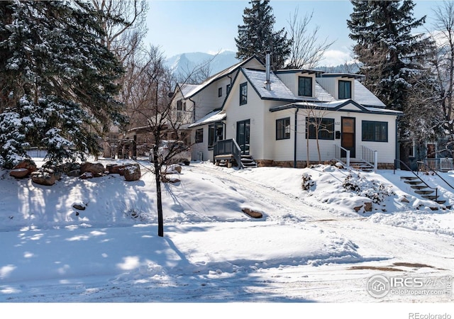 view of front of home with entry steps and a mountain view