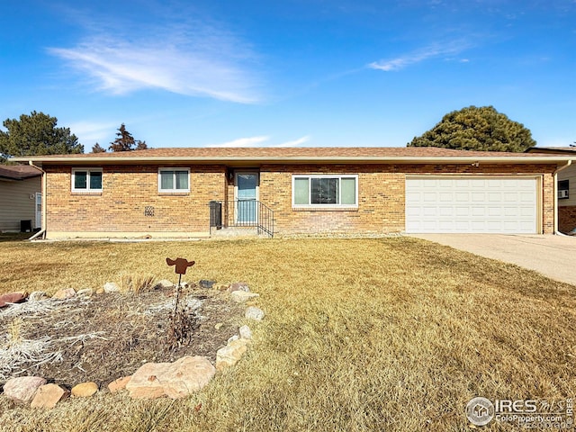 single story home with a garage, concrete driveway, brick siding, and a front yard