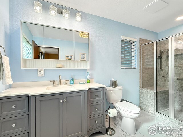 bathroom featuring toilet, a stall shower, tile patterned flooring, and vanity