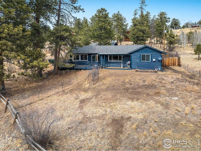 ranch-style home featuring fence