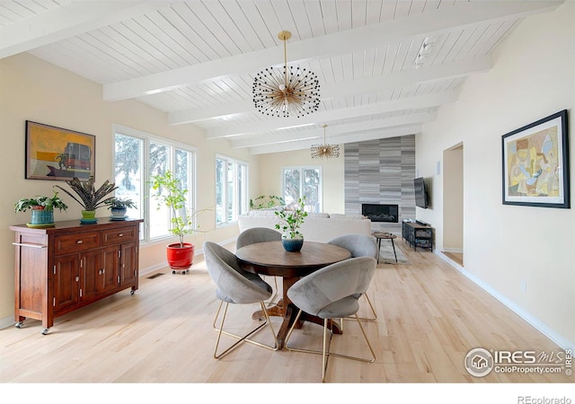 7034 Indian Peaks Trl, Boulder, CO 80301 - dining area featuring light wood-style flooring, baseboards, a chandelier, a large fireplace, and beamed ceiling