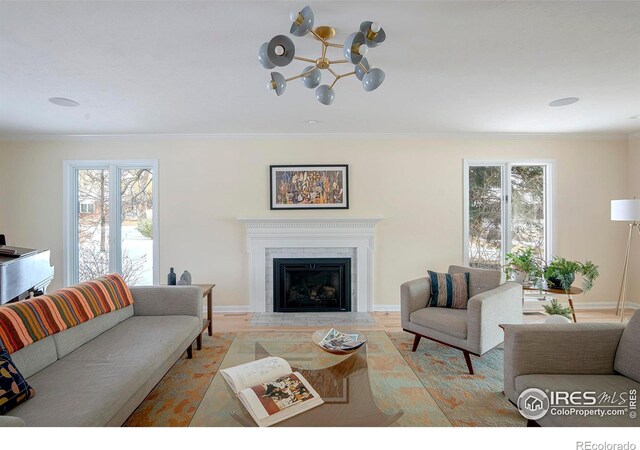 7034 Indian Peaks Trl, Boulder, CO 80301 - living room featuring crown molding, a fireplace with flush hearth, baseboards, and a chandelier