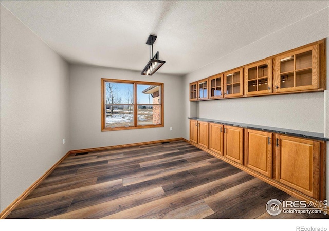 11837 County Road 39, Fort Lupton, CO 80621 - unfurnished dining area with dark wood-style flooring, baseboards, and a textured ceiling