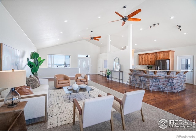 living area with high vaulted ceiling, plenty of natural light, wood finished floors, and recessed lighting