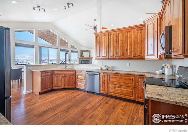 kitchen featuring a ceiling fan, appliances with stainless steel finishes, dark wood finished floors, and a sink