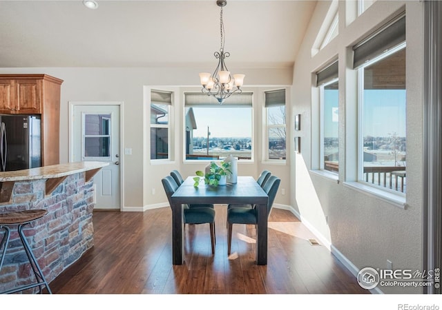 dining room featuring baseboards, dark wood-type flooring, lofted ceiling, and an inviting chandelier