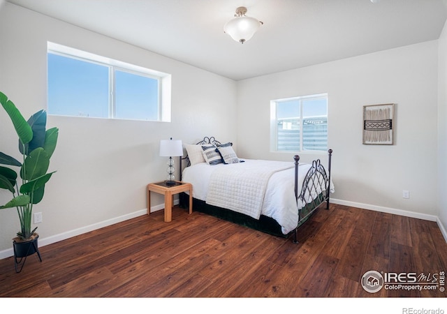 bedroom featuring hardwood / wood-style flooring and baseboards