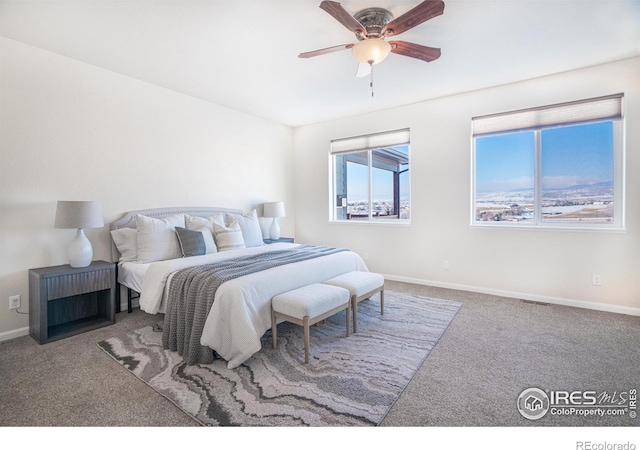 carpeted bedroom with visible vents, baseboards, and ceiling fan