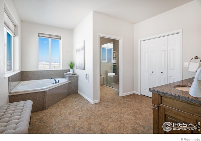 full bathroom with a garden tub, baseboards, and vanity