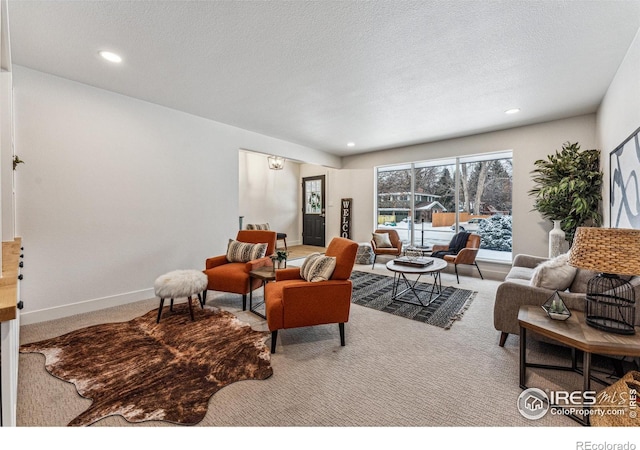 living area featuring a textured ceiling, carpet floors, recessed lighting, and baseboards