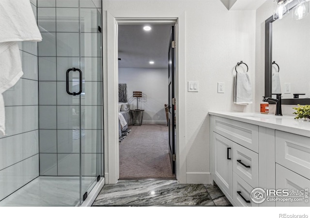 ensuite bathroom featuring a stall shower, marble finish floor, connected bathroom, and vanity