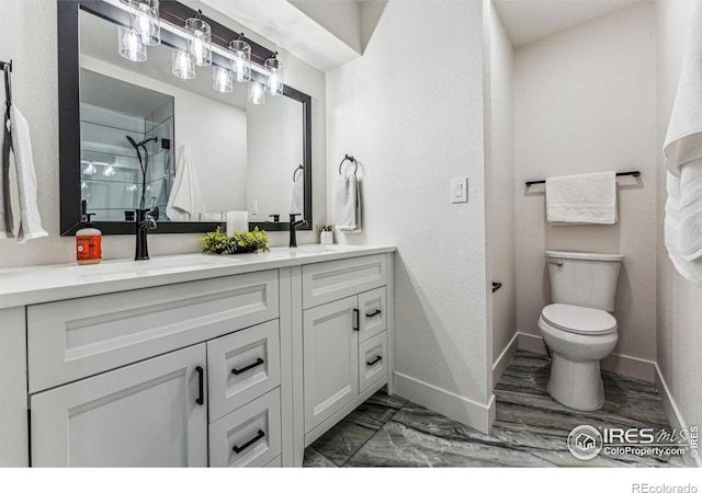 bathroom with double vanity, toilet, a sink, baseboards, and walk in shower