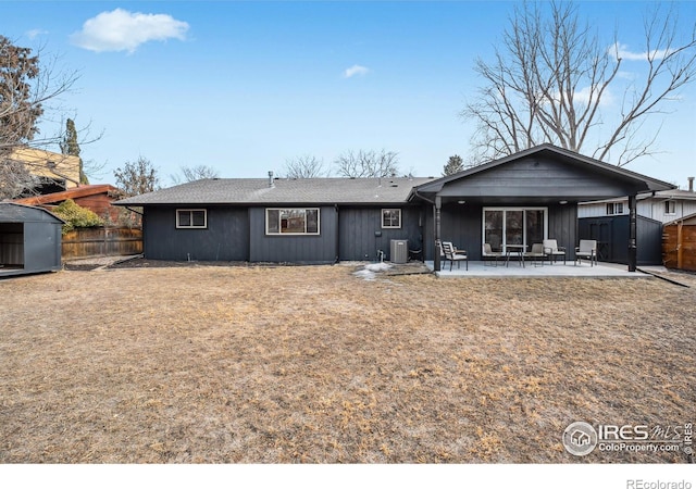 back of property featuring cooling unit, an outdoor structure, fence, a storage unit, and a patio area