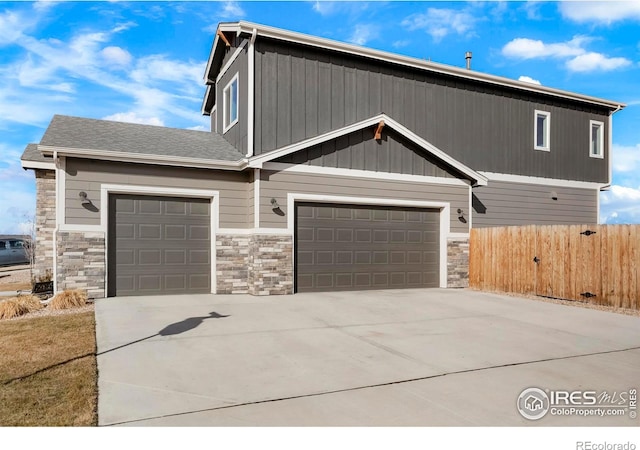 view of front of house featuring a garage, driveway, and fence