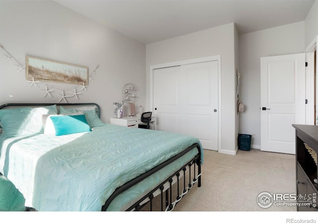 bedroom featuring light carpet, baseboards, and a closet