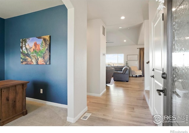 hallway with arched walkways, recessed lighting, visible vents, wood finished floors, and baseboards