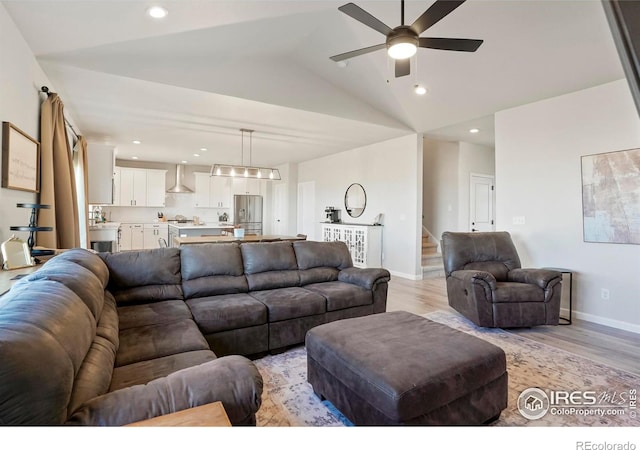 living area featuring lofted ceiling, recessed lighting, a ceiling fan, light wood-style floors, and stairway