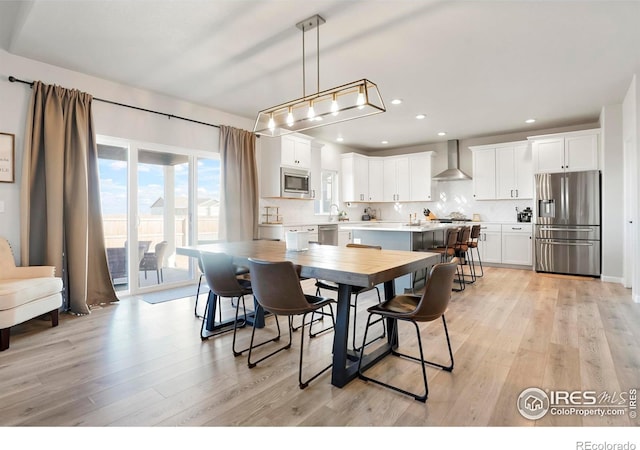 dining space featuring recessed lighting and light wood-style flooring