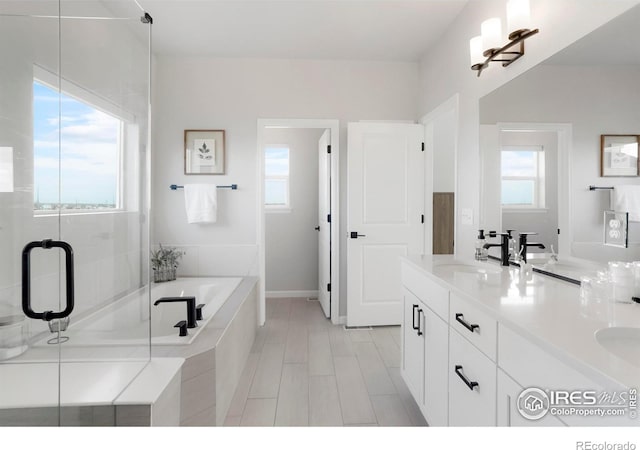 full bathroom with double vanity, a stall shower, a sink, and a bath