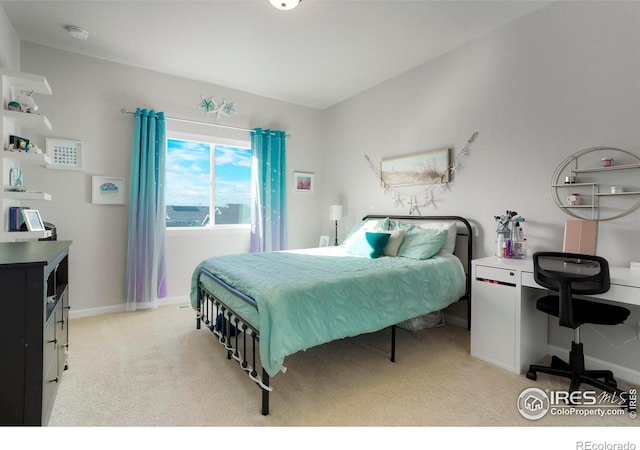 bedroom featuring light carpet and baseboards