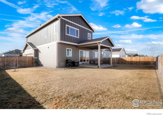 back of house featuring a patio area, a fenced backyard, board and batten siding, and a yard