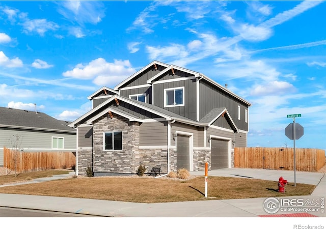 craftsman-style house featuring a garage, concrete driveway, fence, a front lawn, and board and batten siding