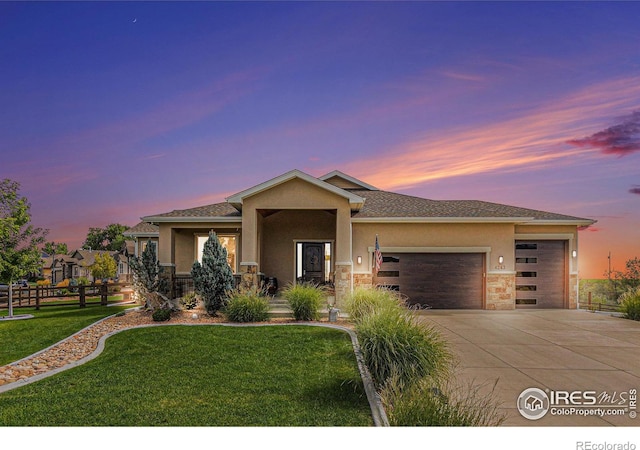 view of front of property featuring a garage, a front yard, driveway, and stucco siding