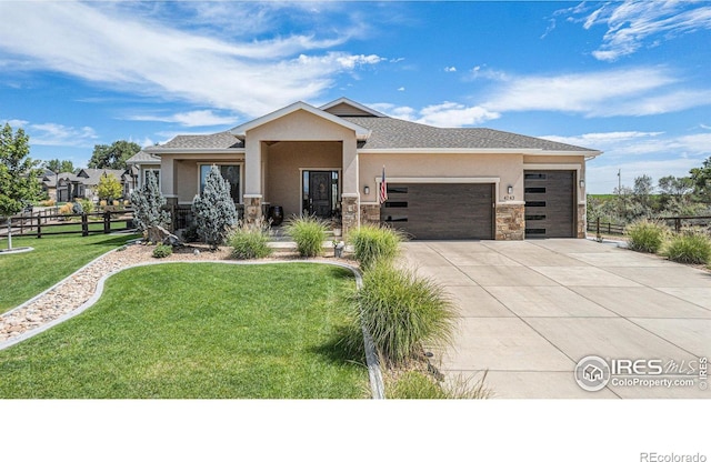 view of front of home featuring driveway, stucco siding, an attached garage, fence, and a front yard