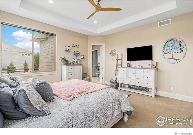 bedroom featuring a tray ceiling, recessed lighting, visible vents, and baseboards