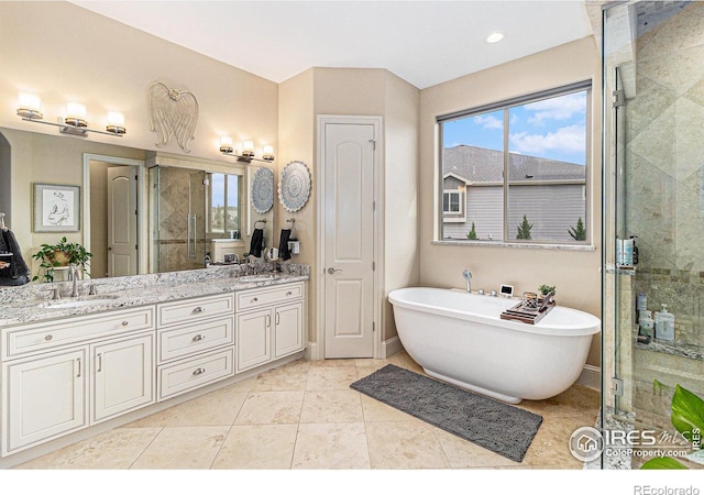 bathroom with double vanity, a stall shower, a sink, and a soaking tub