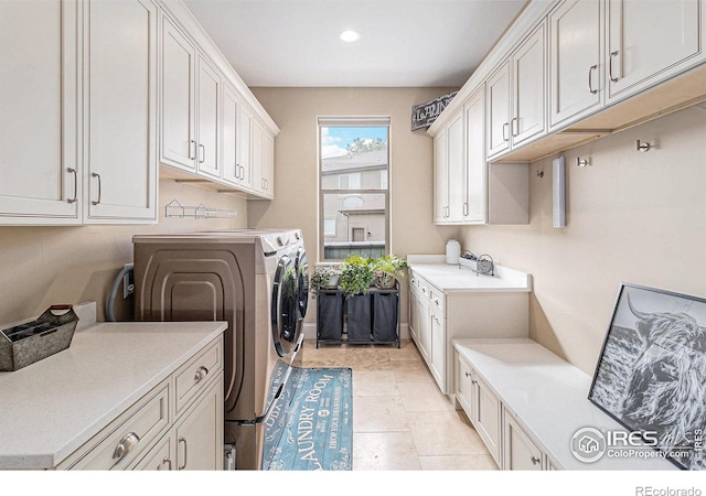 laundry area with recessed lighting, cabinet space, a sink, and washer and clothes dryer