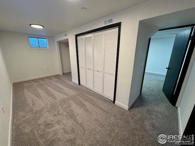 unfurnished bedroom with carpet floors, visible vents, and baseboards