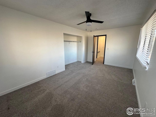 unfurnished bedroom with carpet flooring, visible vents, a textured ceiling, and baseboards