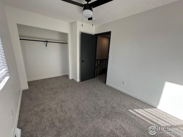 unfurnished bedroom featuring carpet, a closet, a ceiling fan, a textured ceiling, and baseboards