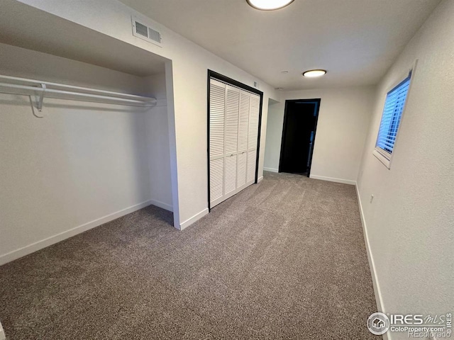 unfurnished bedroom featuring carpet floors, visible vents, and baseboards