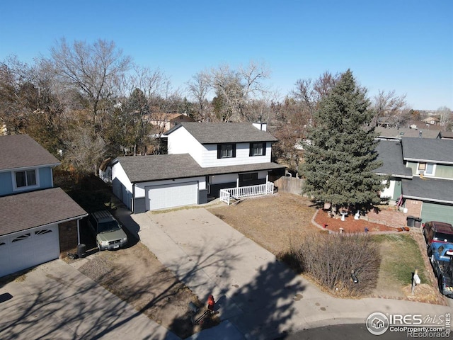 view of front of property with a garage, a residential view, fence, and concrete driveway