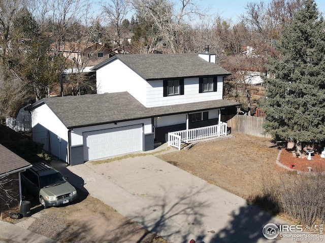 traditional home featuring a porch, a garage, concrete driveway, roof with shingles, and a chimney