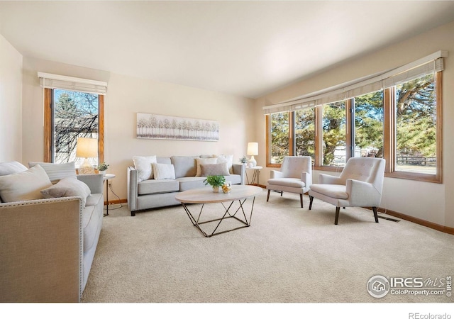 carpeted living room with a wealth of natural light, visible vents, and baseboards