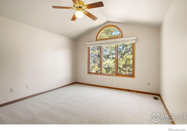 empty room with light carpet, visible vents, and vaulted ceiling