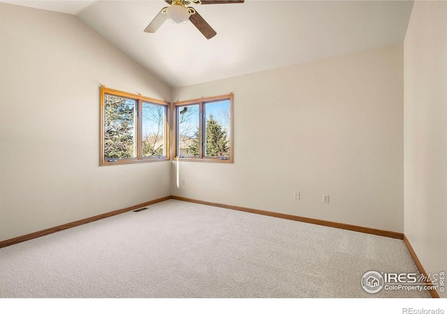 unfurnished room featuring lofted ceiling, ceiling fan, light colored carpet, visible vents, and baseboards