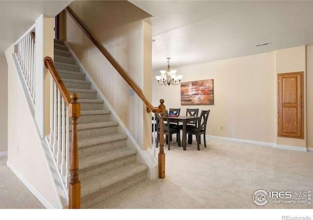 stairway with carpet, visible vents, a chandelier, and baseboards