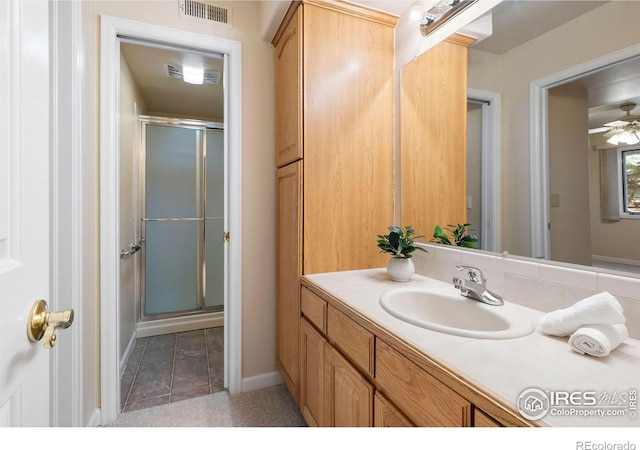 full bathroom featuring vanity, a shower stall, visible vents, and a ceiling fan