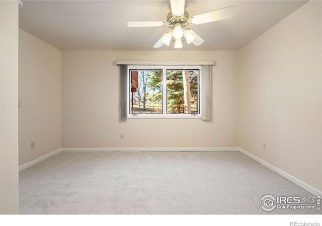 spare room with carpet floors, baseboards, and a ceiling fan