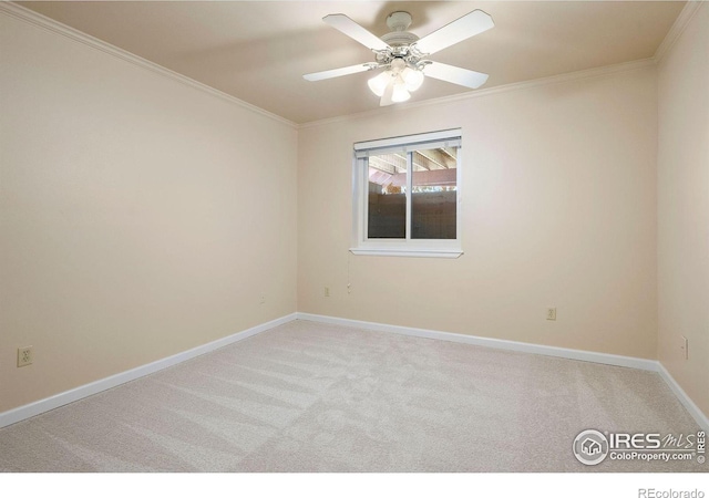 spare room featuring a ceiling fan, carpet, ornamental molding, and baseboards