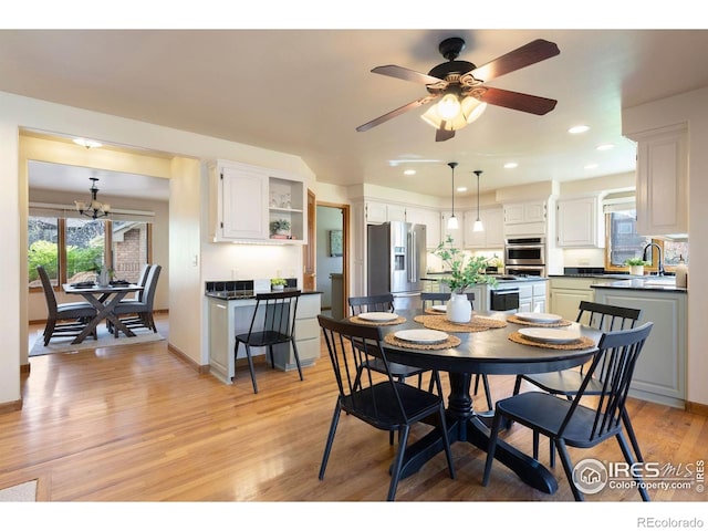 dining area with light wood-type flooring, recessed lighting, baseboards, and ceiling fan with notable chandelier