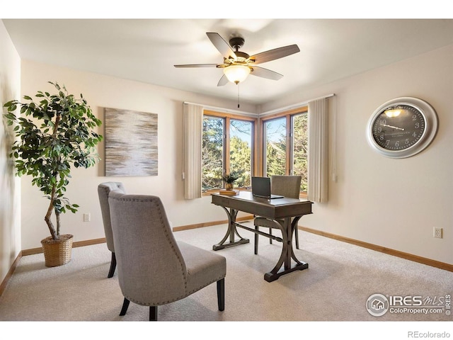 office area featuring baseboards, a ceiling fan, and light carpet