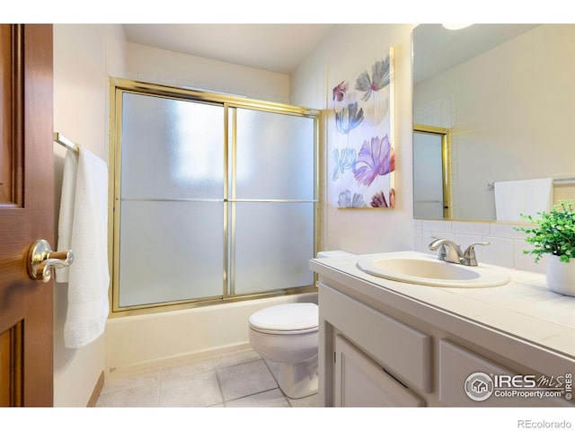 full bathroom with vanity, tile patterned floors, toilet, and shower / bath combination with glass door